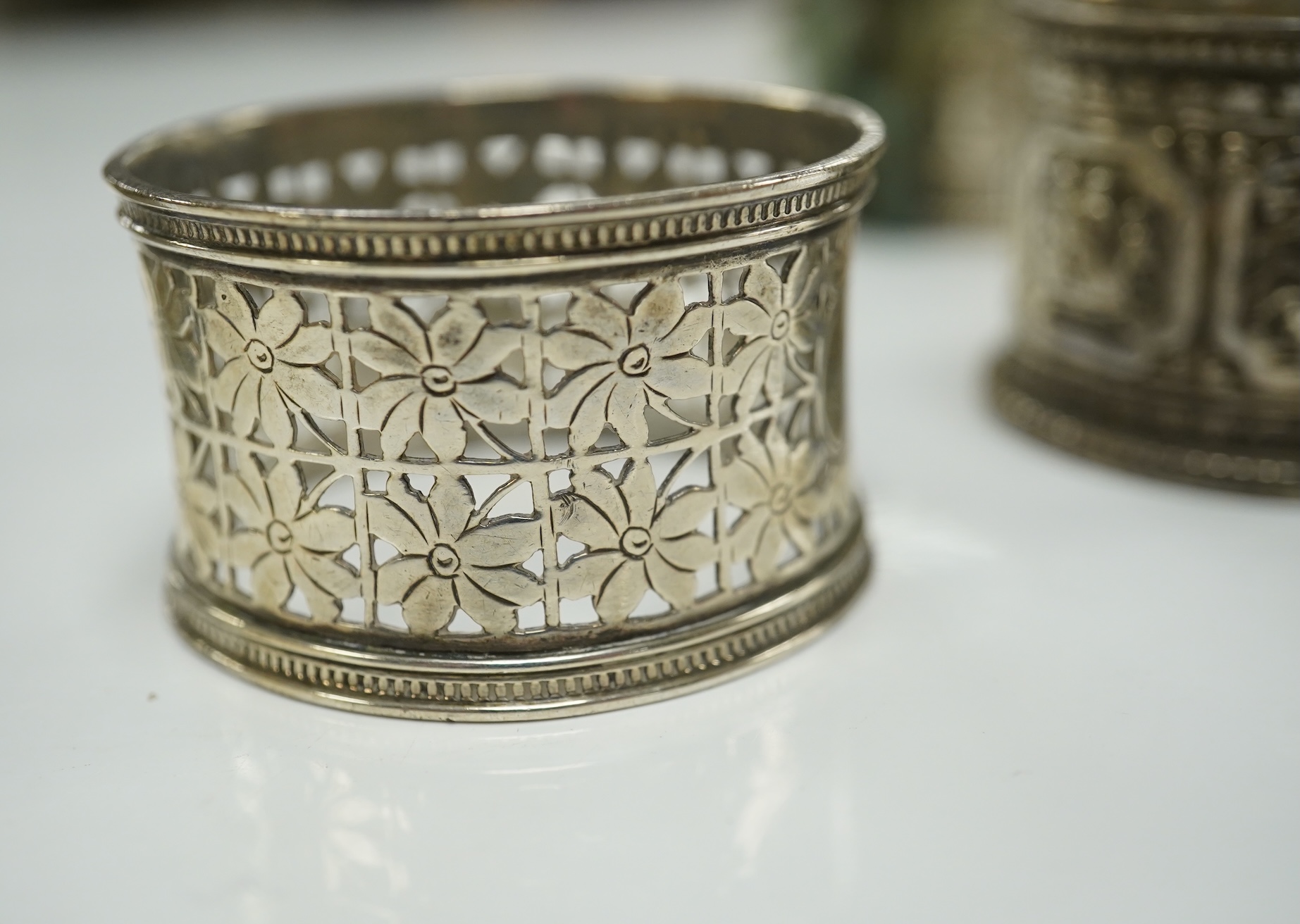 Two pairs of Victorian silver napkin rings and a George III silver wine funnel with later embossed decoration, 14.1cm. Condition - poor to fair